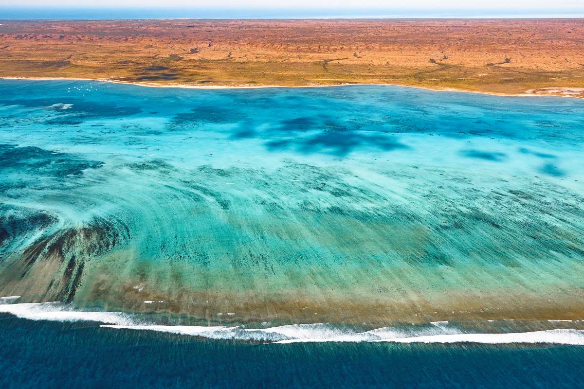 Blue Beach with the Pilbara red landscape int the background 